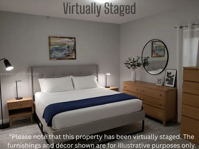 a bedroom with a bed a mirror on dresser and a table