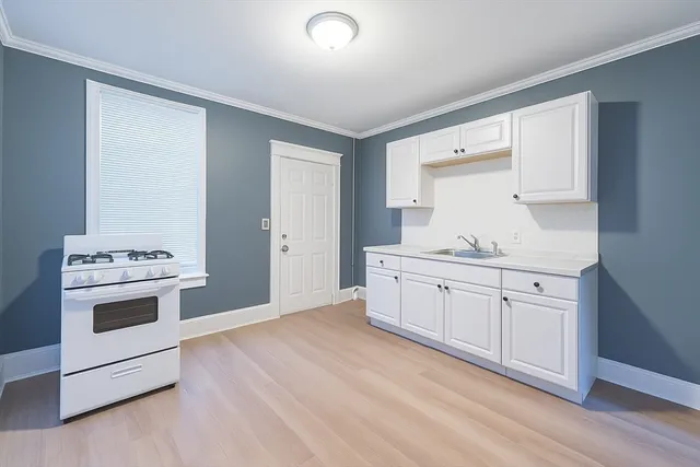 a kitchen with granite countertop white cabinets and white appliances