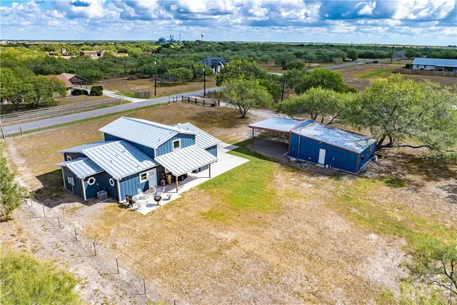 an aerial view of a house with garden space and a patio