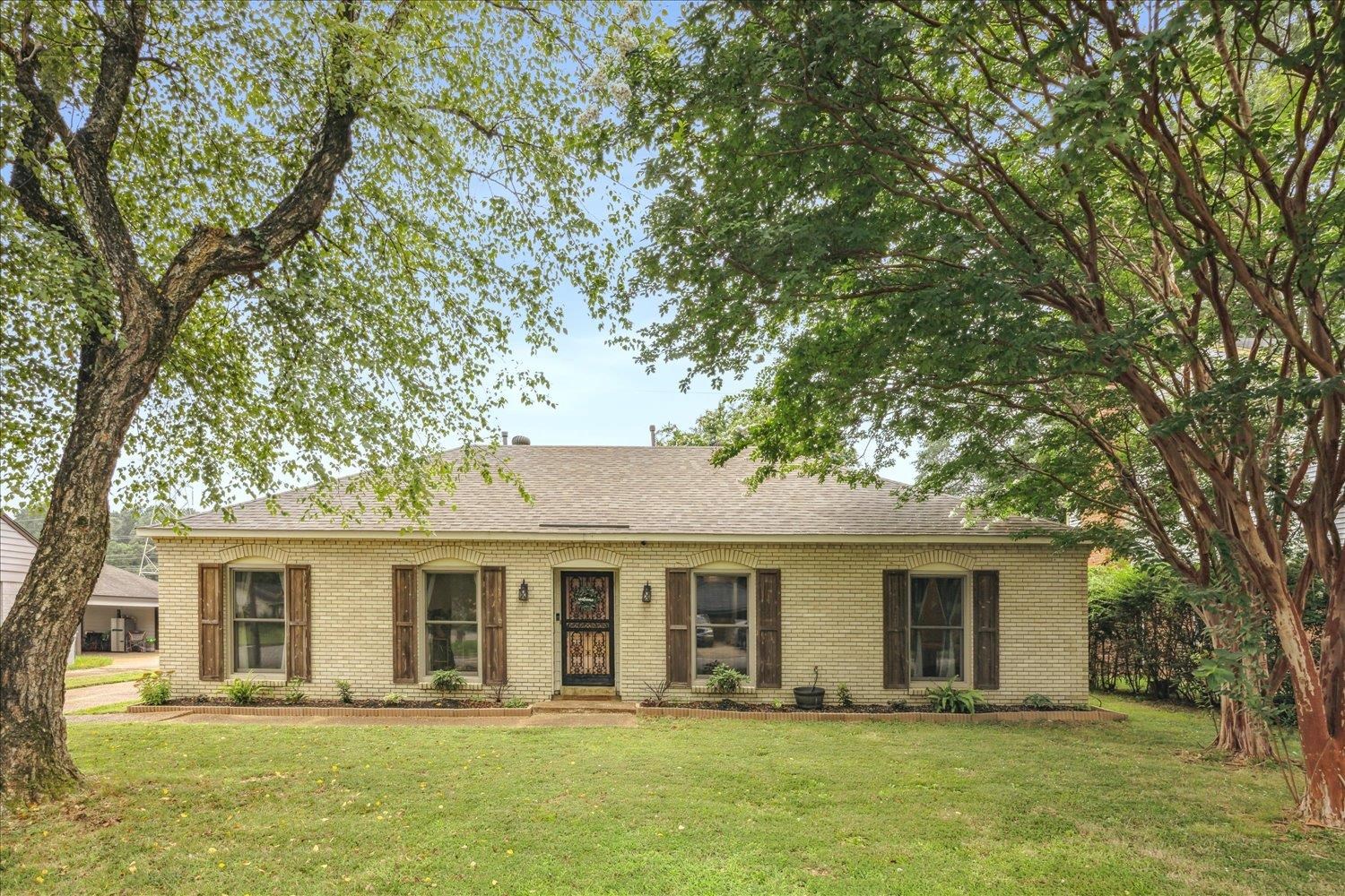 a front view of a house with a tree in it