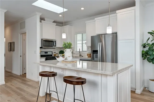 a kitchen with stainless steel appliances granite countertop a refrigerator and a stove top oven