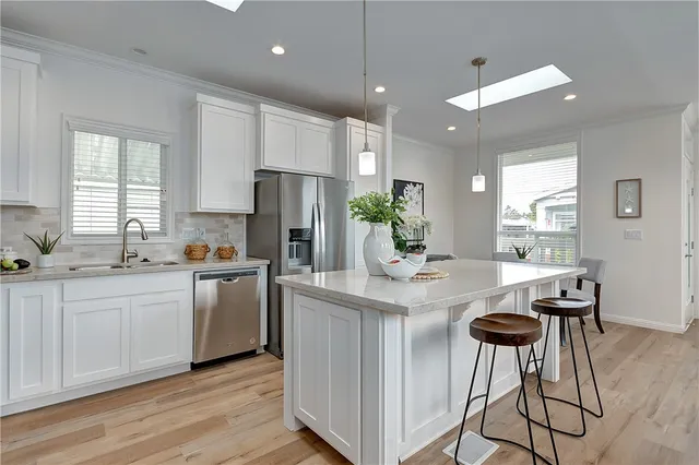 a kitchen with stainless steel appliances kitchen island a table and chairs in it