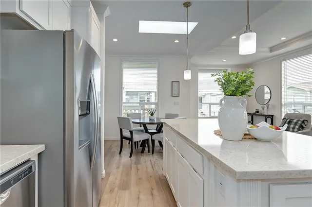 a kitchen with kitchen island granite countertop a sink a counter top space and living room view