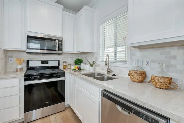 a kitchen with stainless steel appliances a stove microwave and sink