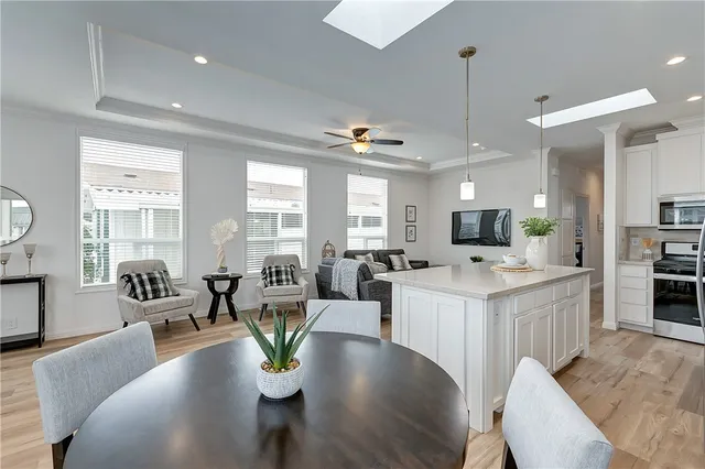 a large living room with stainless steel appliances kitchen island granite countertop a table chairs and a view of living room