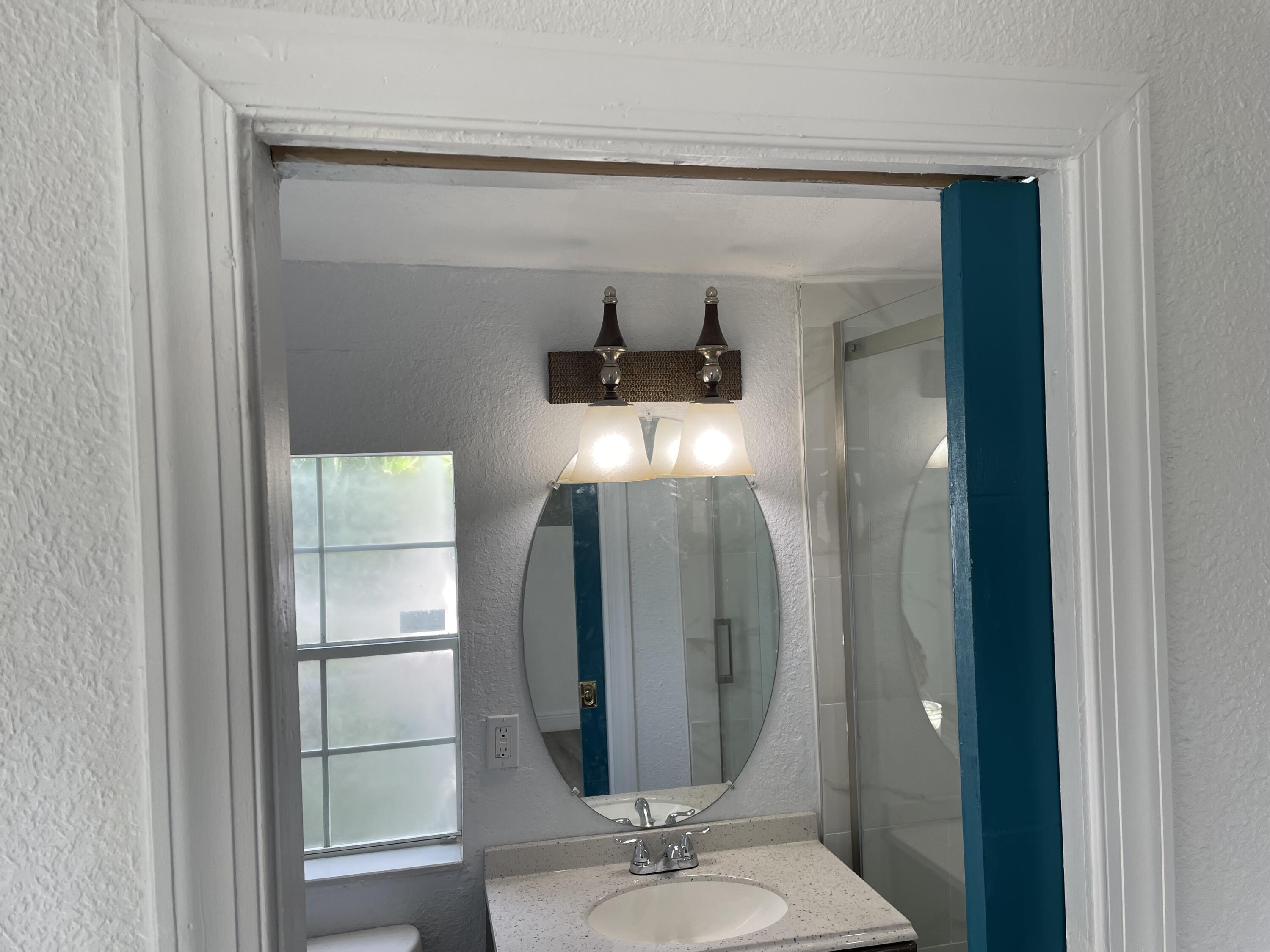 825 West 3rd Street, Unit 4 Riviera Beach, FL 33404 - Photo 5 of 7 a bathroom with a mirror and a shower