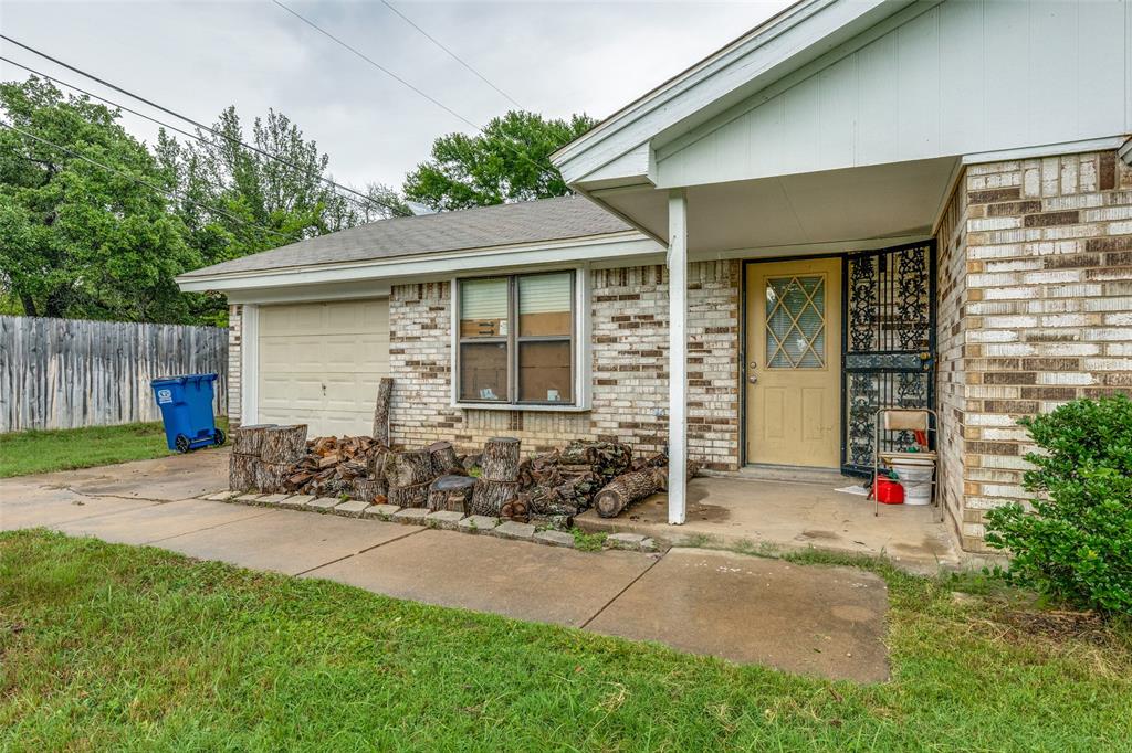 101 Gordon Drive Azle, TX 76020 - Photo 1 of 25 Doorway to property with a garage, brick siding, and a shingled roof