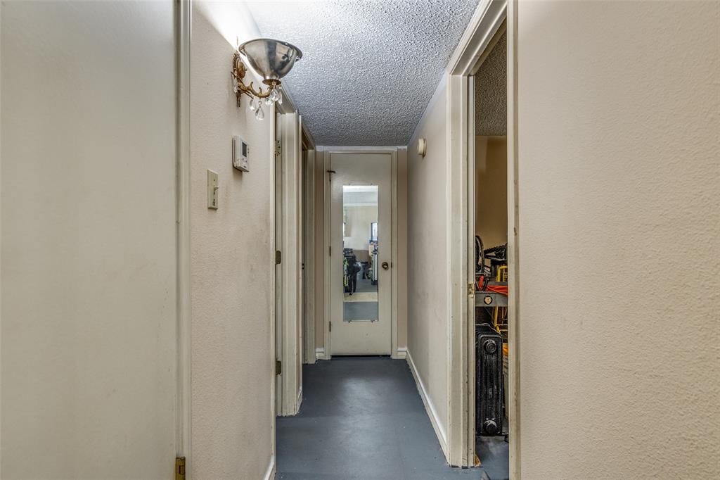 101 Gordon Drive Azle, TX 76020 - Photo 15 of 25 Hallway featuring finished concrete flooring, a textured ceiling, and a textured wall