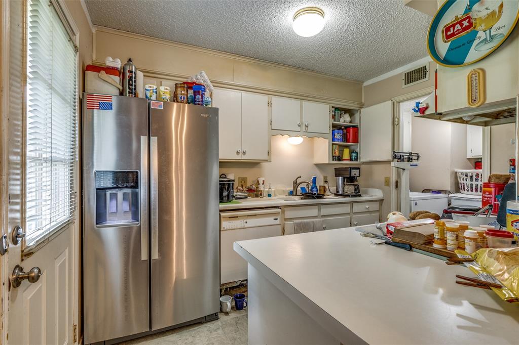 101 Gordon Drive Azle, TX 76020 - Photo 10 of 25 Kitchen featuring stainless steel fridge, white dishwasher, a textured ceiling, light countertops, and separate washer and dryer