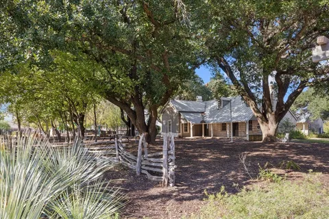 a front view of a house with a tree