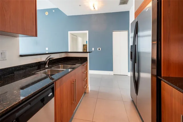 a kitchen with stainless steel appliances granite countertop a refrigerator and a sink