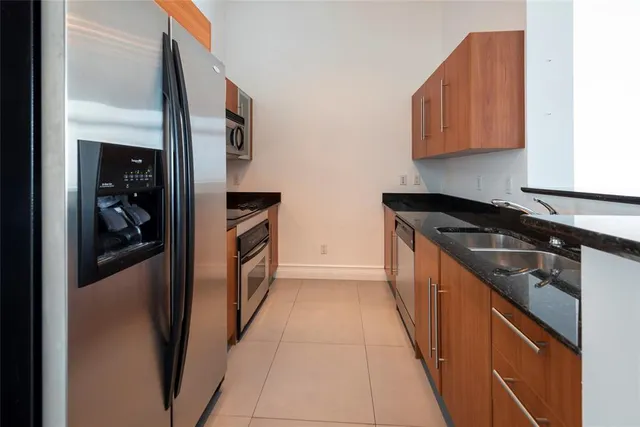 a kitchen with stainless steel appliances granite countertop a refrigerator and a stove