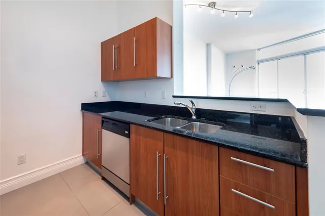 a kitchen with granite countertop stainless steel appliances sink and cabinets