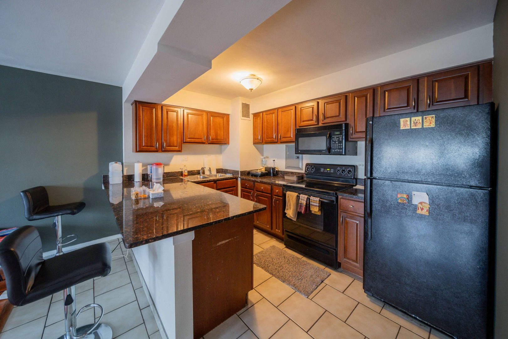 6030 North Sheridan Road, Unit 2011 Chicago, IL 60660 - Photo 7 of 26 a kitchen with stainless steel appliances granite countertop a refrigerator a stove and a sink with wooden cabinets