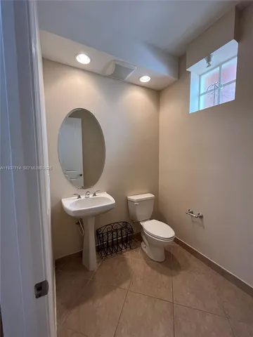 a bathroom with a toilet a sink and a mirror