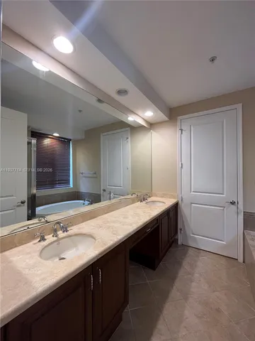 a bathroom with a sink double vanity granite and a mirror
