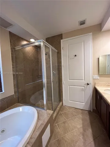 a bathroom with a tub a sink and a shower