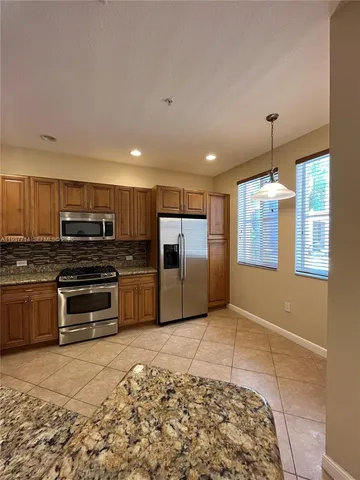 a kitchen with stainless steel appliances granite countertop a stove and a refrigerator