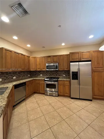 a kitchen with stainless steel appliances a refrigerator and a stove