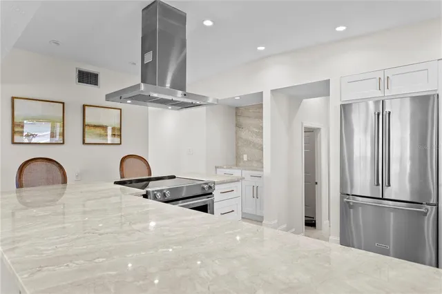a kitchen with stainless steel appliances a refrigerator and a stove top oven