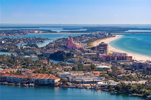 an aerial view of ocean and residential houses with outdoor space