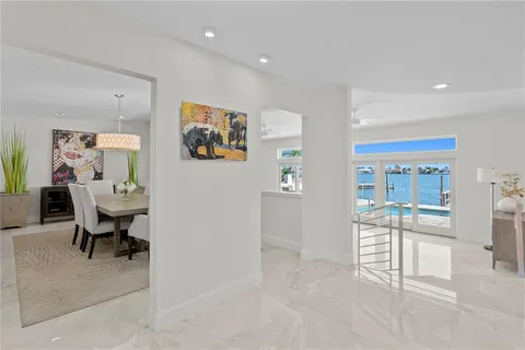 a living room with furniture a dining table and a refrigerator