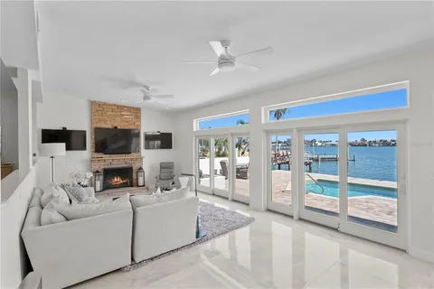 a living room with furniture a flat screen tv and a floor to ceiling window