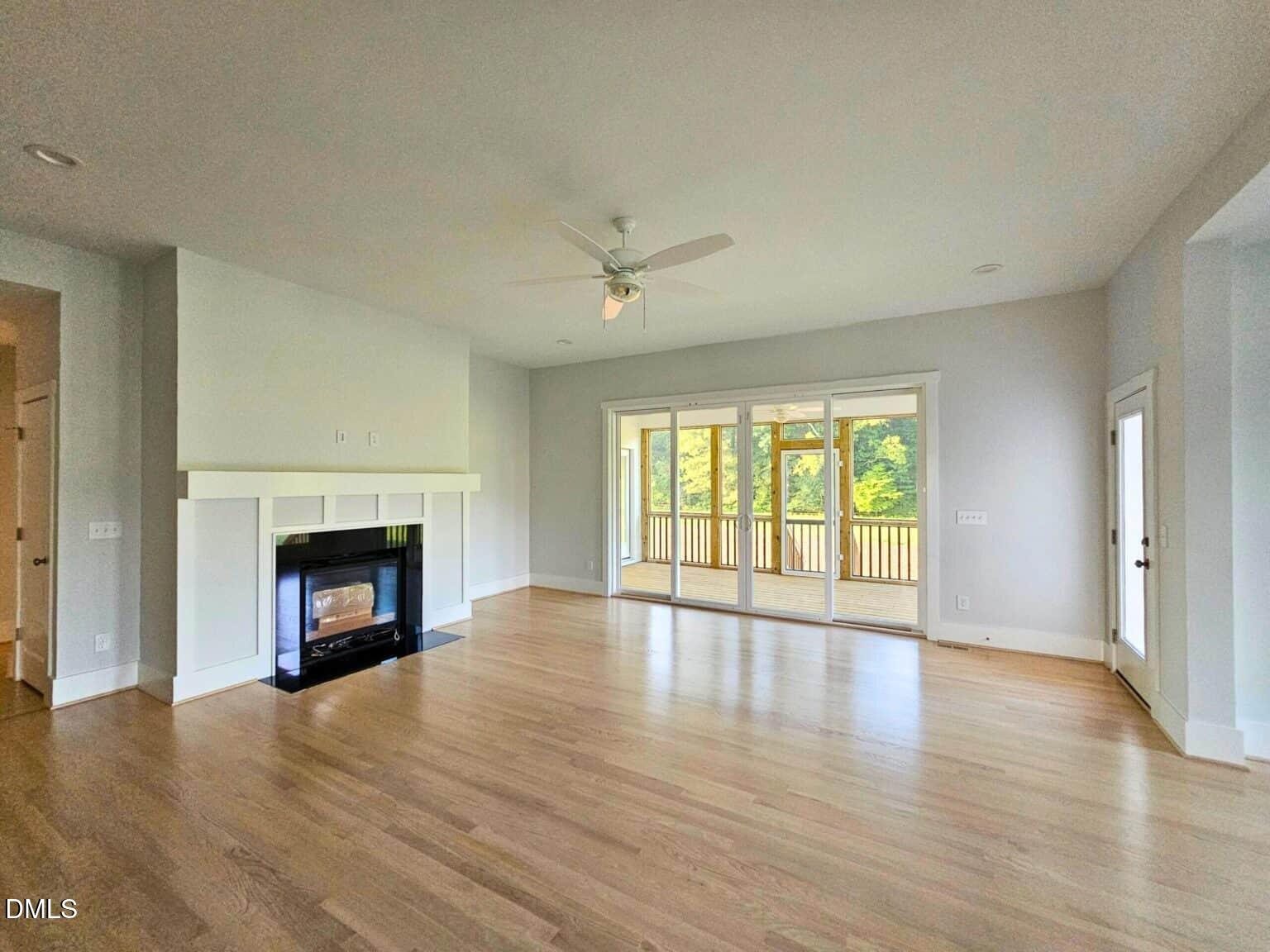 5491 Silk Hope Gum Spring Road Siler City, NC 27344 - Photo 6 of 17 wooden floor fireplace and windows in an empty room