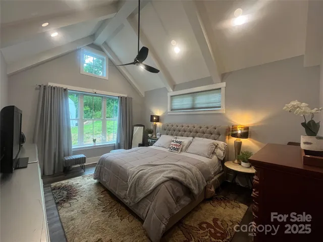 a bedroom with a bed window and a flat screen tv