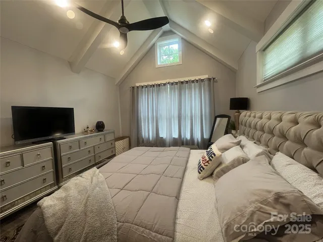 a bedroom with a large bed and a flat screen tv