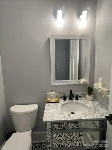 a bathroom with a granite countertop sink and a toilet