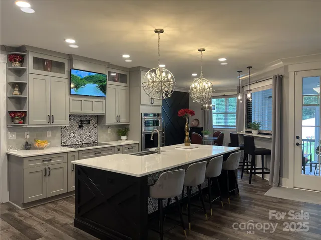 a kitchen with a dining table chairs sink and cabinets