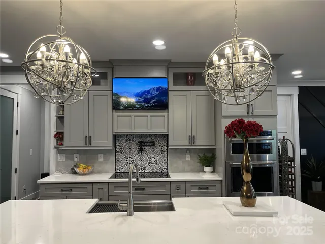 a kitchen with a refrigerator and a chandelier
