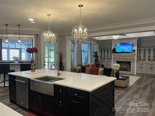 a view of a dining room with furniture a chandelier and kitchen view