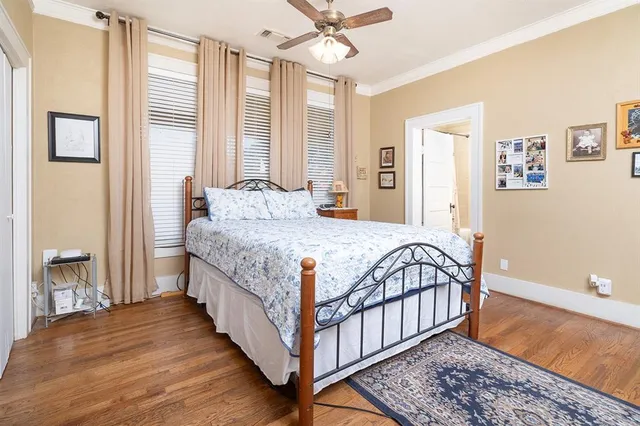 a large bedroom with a bed and wooden floor