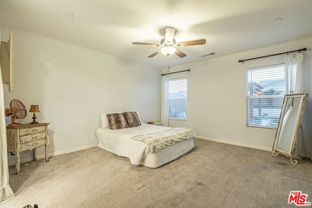 a spacious bedroom with a bed and a chandelier