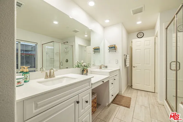 a spacious bathroom with a shower sink and mirror