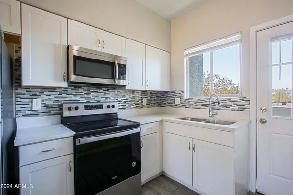 a kitchen with cabinets stainless steel appliances a sink and a window