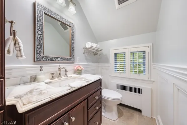 a bathroom with a granite countertop sink a toilet and a mirror