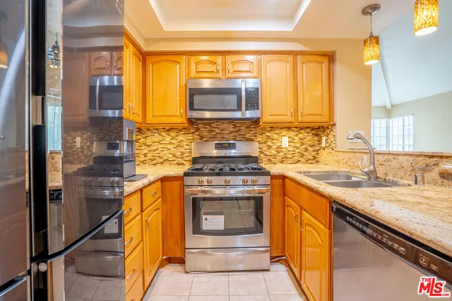 a kitchen with stainless steel appliances granite countertop a stove and a sink