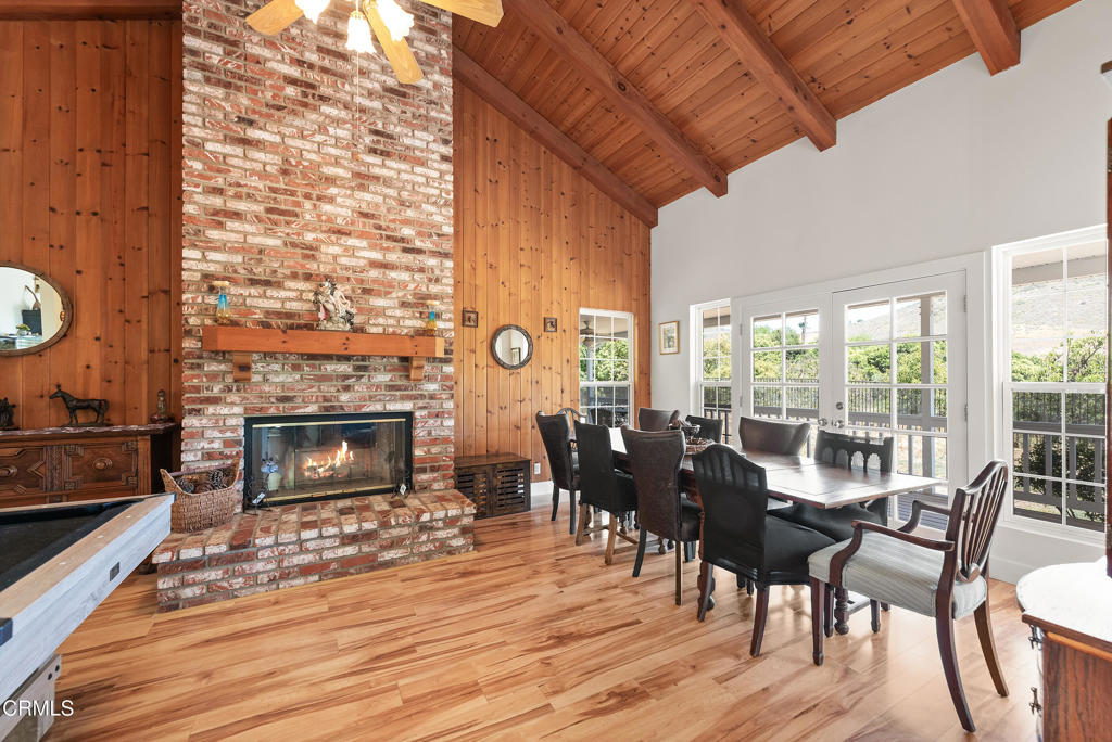 4850 North Moorpark Road Thousand Oaks, CA 93021 - Photo 48 of 54 a dining room with furniture a fireplace and wooden floor