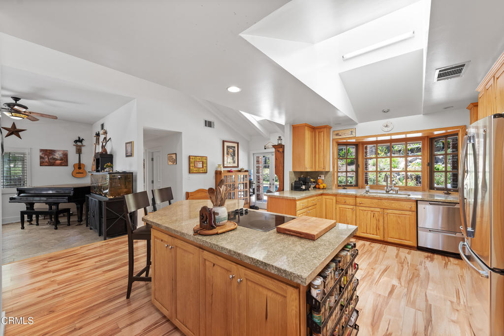 4850 North Moorpark Road Thousand Oaks, CA 93021 - Photo 52 of 54 a open kitchen with stainless steel appliances granite countertop a stove refrigerator and dining table with wooden floor