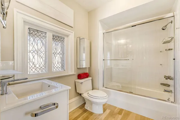 a bathroom with a granite countertop sink toilet a shower and a bathtub