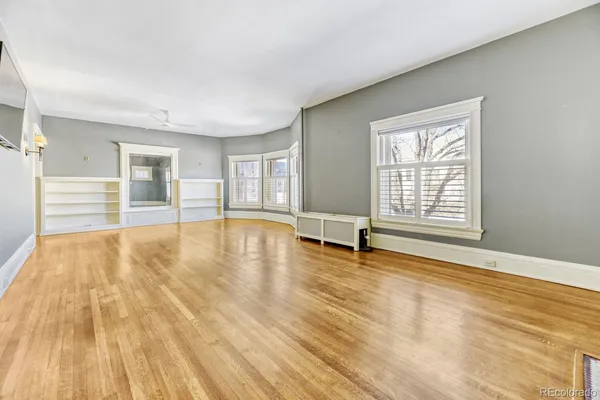 a view of a livingroom with wooden floor and a chandelier