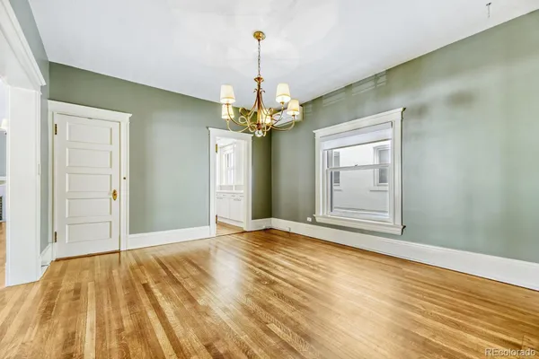 a view of a livingroom with wooden floor and a chandelier