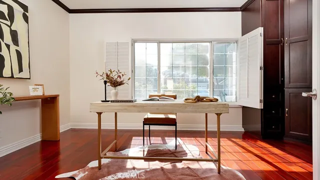 a living room with a table and chair with wooden floor