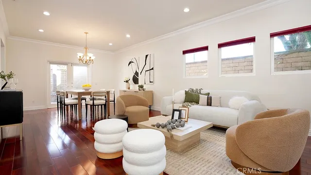 a living room with furniture kitchen view and a large window