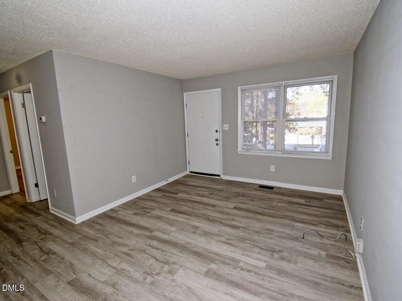 841 Barringer Drive, Unit A Raleigh, NC 27606 - Photo 3 of 23 an empty room with wooden floor and windows
