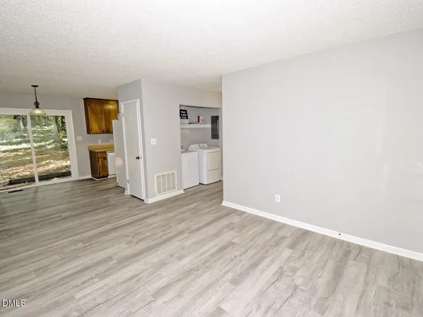a view of empty room with wooden floor
