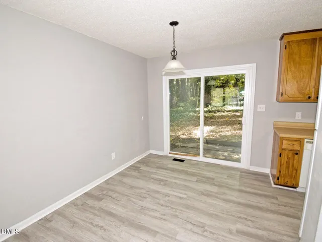 a view of wooden floor cabinets and a window in an empty room